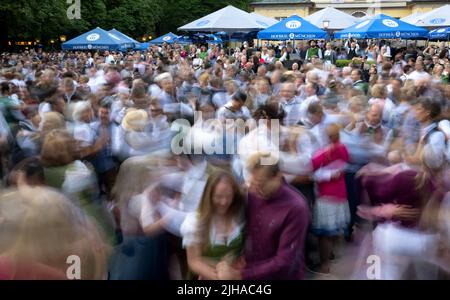 Munich, Germany. 17th July, 2022. Numerous people dance at the traditional Kocherlball at the Chinese Tower in the English Garden. The Kocherlball goes back to an old Munich tradition. In the 19th century, on beautiful summer Sundays, the servants - the 'Kocherl' - gathered to dance. They came early in the morning because they had to work for their masters afterwards. Credit: Sven Hoppe/dpa/Alamy Live News Stock Photo