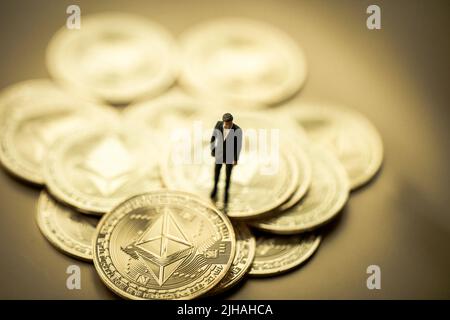 Stack of golden ether coins or Ethereum coins close up on golden background depicting cryptocurrency and digital money Stock Photo