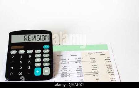 On the white table there is a document and a calculator with Revision written on it. business concept Stock Photo