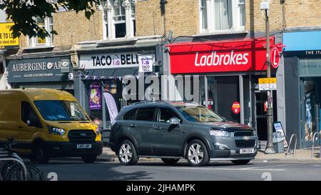 London, UK - July 14, 2022: Shops on high street in Wimbledon, London, UK including Ladbrokes and Taco Bell Stock Photo