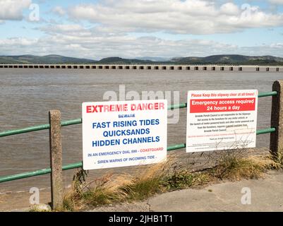 A sign warning of extreme danger due to fast rising tides and quicksand in Arnside, Cumbria, England, UK Stock Photo
