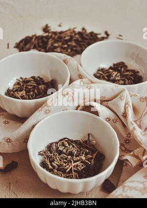 Small bowls with dried healing green tea and herbs, ritual purification and cleansing, closeup Stock Photo