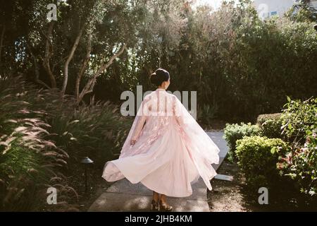 A back view of a young woman twirling in a traditional Chinese wedding Stock Photo