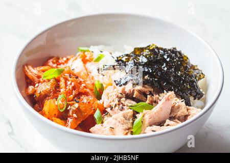 Kimchi tuna rice salad in a white bowl. Traditional Korean food. Stock Photo