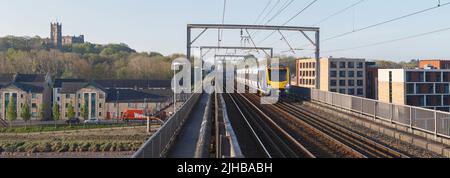 Northern Rail class 195  train crossing  Carlisle Bridge (Lancaster, river Lune)  with Lancaster Priory and castle on the left Stock Photo