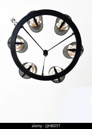 Low angle view of geometric circle shape of electric lamp hanging on ceiling Stock Photo