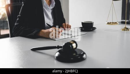 Judge gavel with Justice lawyers, Business woam in suit or lawyer working on a documents. Legal law, advice and justice concept. Stock Photo