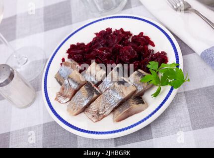 Sliced herring with grated beetroot served on table Stock Photo