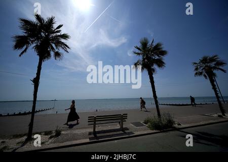 People walk along the Western Esplanade at Southend-on-Sea on the Thames Estuary in Essex. Temperatures are predicted to hit 31C across central England on Sunday ahead of record-breaking highs next week. Picture date: Sunday July 17, 2022. Stock Photo