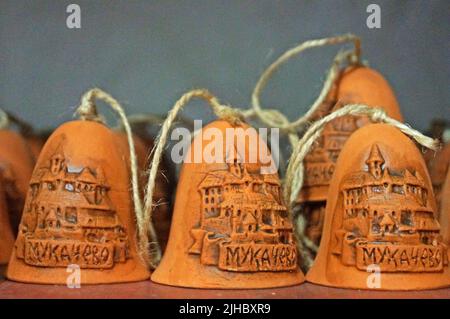 Clay bells on ribbons on the counter in the souvenir shop are made in Ukraine Stock Photo