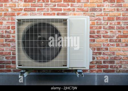 Heat pump air conditioning outdoor unit hanging on wall. Stock Photo