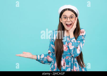 Look at advert. Teenager child points aside shows blank copy space for text promo idea presentation, poses. Excited teenager, amazed and cheerful Stock Photo