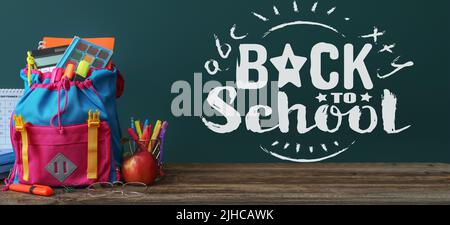 Backpack with stationery and apple on table. Back to school Stock Photo