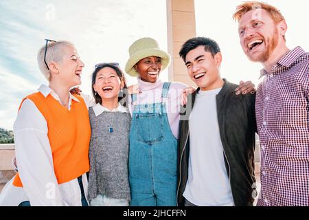 Group of multiracial friends meeting smiling and enjoying in a sunny day. Stock Photo