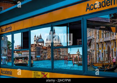 A beautiful reflection of the famous Basilica Santa Maria della Salute at the Accademia boat station at the Grand Canal in Venice, Italy Stock Photo