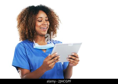 Technology has become such a vital for her. Studio shot of an attractive young nurse using a digital tablet against a white background. Stock Photo
