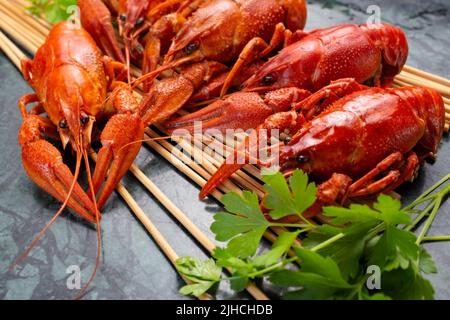 Fresh boiled red crayfish on a wooden stand with parsley. Great snack for beer. Stock Photo