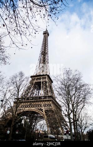 A vertical low-angle shot of the Eiffel tower surrounded by leafless trees Stock Photo