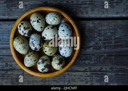 Fresh quail eggs close up on a wooden table small hard boiled eggs rustic top view Stock Photo