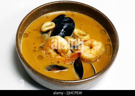 famous french classic seafood bisque soup in a bowl with shrimp, lobster, crab, cuttlefish, squid, mussels and clams Stock Photo