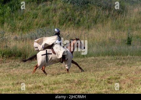 Knight of the Teutonic Order is galloping across a field Stock Photo
