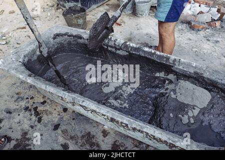 Workers mixing cement by shovels Stock Photo
