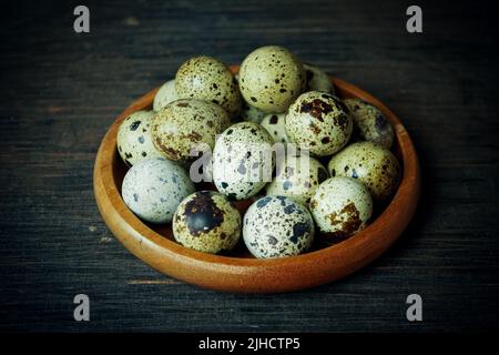 Fresh quail eggs close up on a wooden table small hard boiled eggs rustic top view Stock Photo