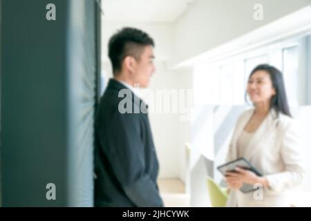 Blurred background of modern office with business colleagues talking to each other. Copy space. Stock Photo
