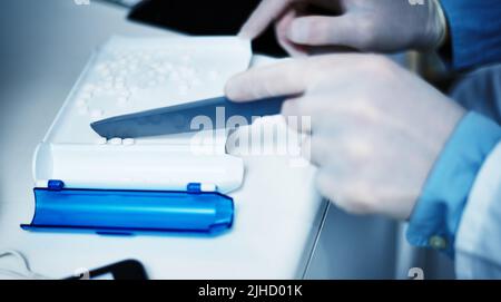 Promoting safe use of medication with accurate counting. a pharmacist counting medication. Stock Photo