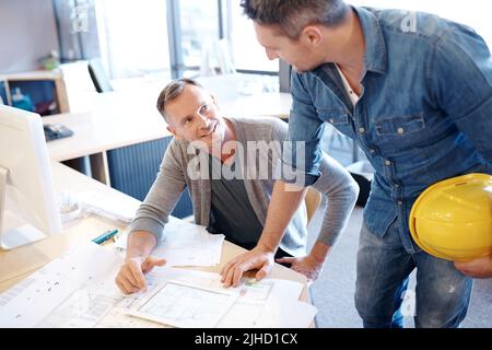 Architects turn space into success. two architects working together on a blueprint with the help of a digital tablet. Stock Photo