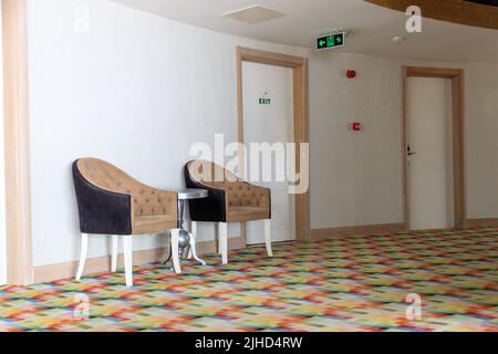 Art Nouveau armchairs stand between rooms in the corridor of a Turkish hotel. Stock Photo
