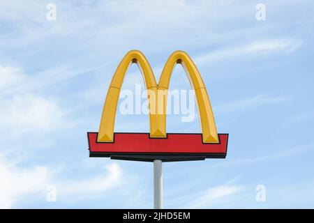 Seattle - July 09, 2022; Golden Arches symbol of McDonalds elevated against pale blue sky Stock Photo