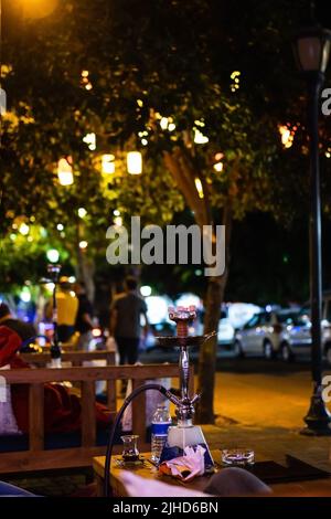 hookah on a street table in the evening in a Turkish traditional hookah bar with lights. Stock Photo