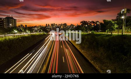 Trail of light caused by vehicular traffic in SP-294, Comandante Joao Ribeiro Barros Highway with buildings from downtown in the background, in Maríli Stock Photo