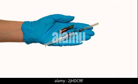 Doctor's hand in a blue rubber glove holds a medical syringe and ampule on a white background. The concept of medicine and medical care for the