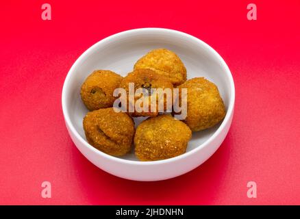 Italian Ascolane Olives, Olive Ascolane, in a bowl isolated on red background Stock Photo