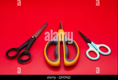 Different shape scissors isolated on red background Stock Photo