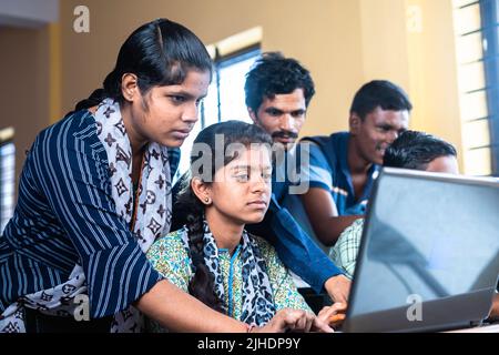 Groups of students seriously using laptop at classroom - concept of technology, education and self learning Stock Photo