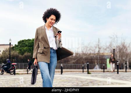 business woman walking confidently using a phone Stock Photo