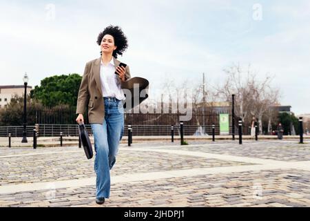 business woman running in a hurry with a phone Stock Photo