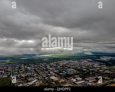 Flying through thick clouds. Rain clouds in the sky. Cumulus clouds, meteorology and climate studies.Photo of the city from the height of clouds, aeri Stock Photo