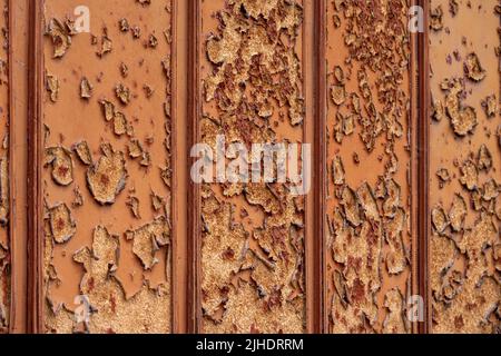 Peeled brown panel. Rough brown wall with stains and peel. Abstract background Stock Photo