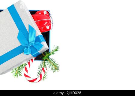 Christmas gift box with gift tied with blue ribbon with bow with green Christmas tree and caramel on white background Stock Photo