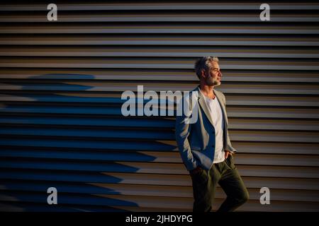 Successful happy businessman waiting in city street, copy space, commuting concept. Stock Photo