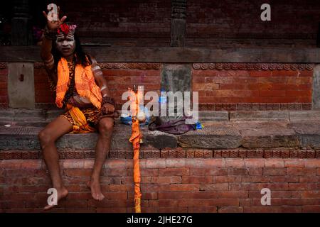 Kathmandu, Nepal. 18th July, 2022. A Sadhu gestures during the holy month of Shrawan at Pashupathinath Temple in Kathmandu, Nepal on Monday, July 18, 2022. Women celebrate the Shrawan month by offering prayers in Shiva temples donning Mehendi (henna tattoos) and green/yellow bangles, praying for a long life for their husbands and fulfillment of their desires and prosperous life for their families. (Credit Image: © Skanda Gautam/ZUMA Press Wire) Credit: ZUMA Press, Inc./Alamy Live News Stock Photo