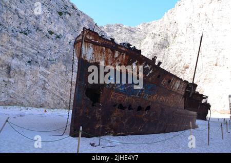 rusty shipwreck with high rocks in background at Naviago beach, Zakynthos, greece Stock Photo