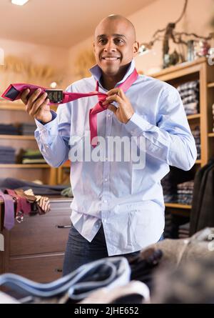 Man choosing new tie in clothing boutique Stock Photo - Alamy