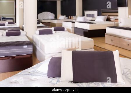 Closeup of pillows on modern comfortable orthopedic mattress on display for sale in furniture store, with copyspace Stock Photo