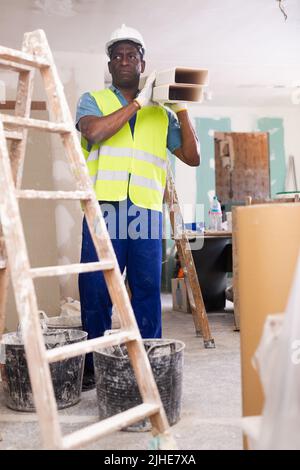 Portrait of an african american builder, working in the process of repair Stock Photo