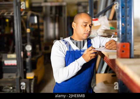 Confident worker taking inventory in building materials store Stock Photo